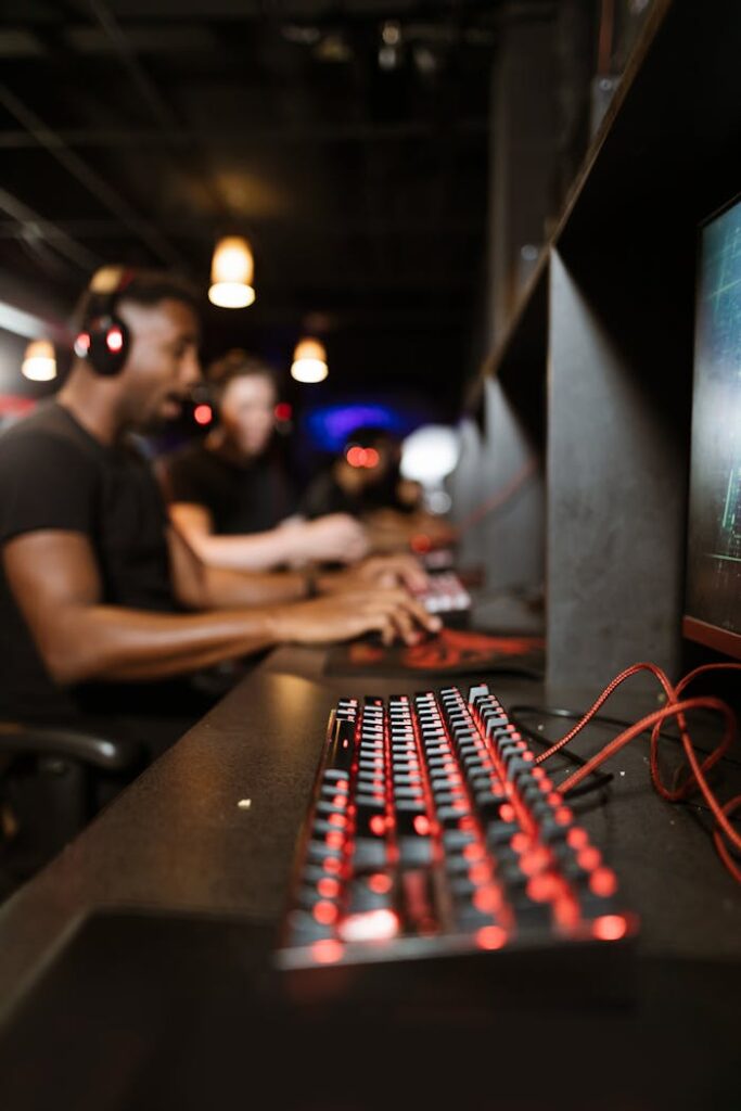 Gamers engrossed in a session using mechanical keyboards, highlighting vibrant LED lighting.